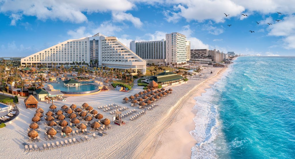 Turquoise waves meeting the soft sands of Cancun’s hotel zone under a clear blue sky.