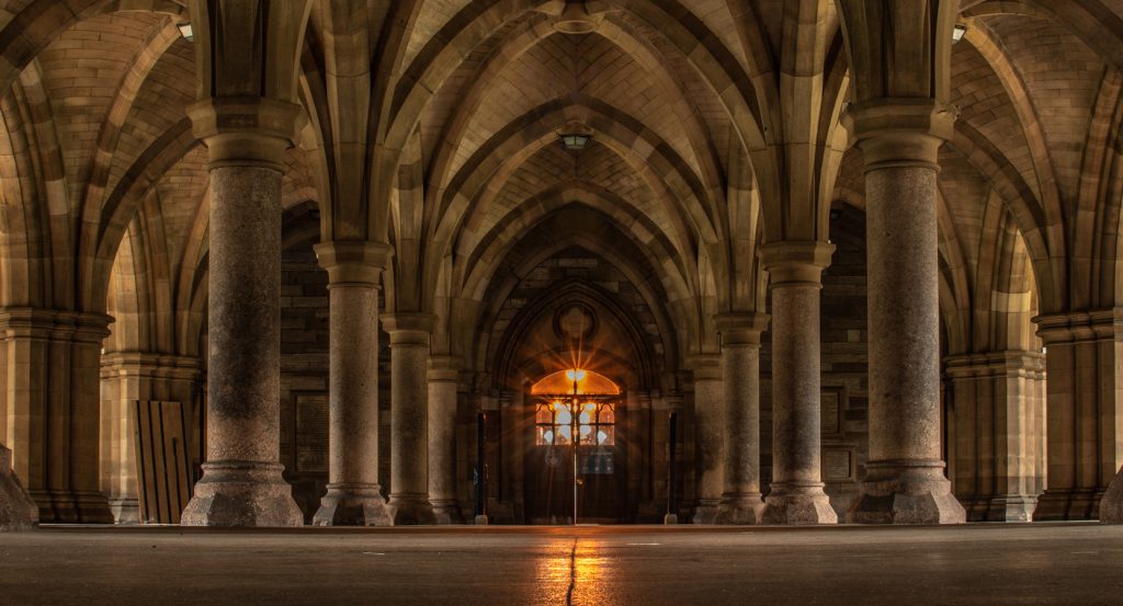 Vaulted cathedral-style hallway with glowing doorway in Scotland