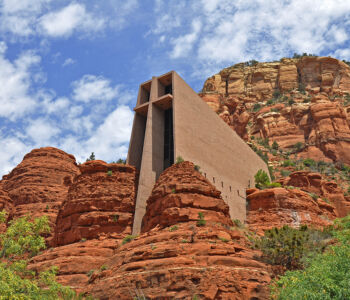 Chapel of the Holy Cross rising from Sedona’s red rock cliffs under a partly cloudy sky