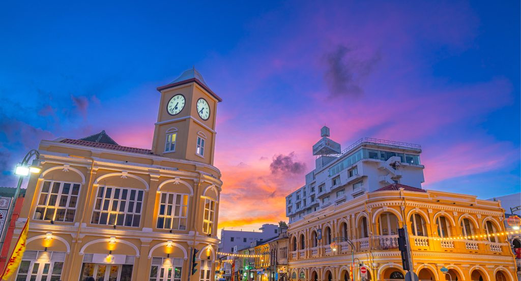 Historic buildings in Phuket Old Town glow beneath a vivid purple and orange twilight sky.