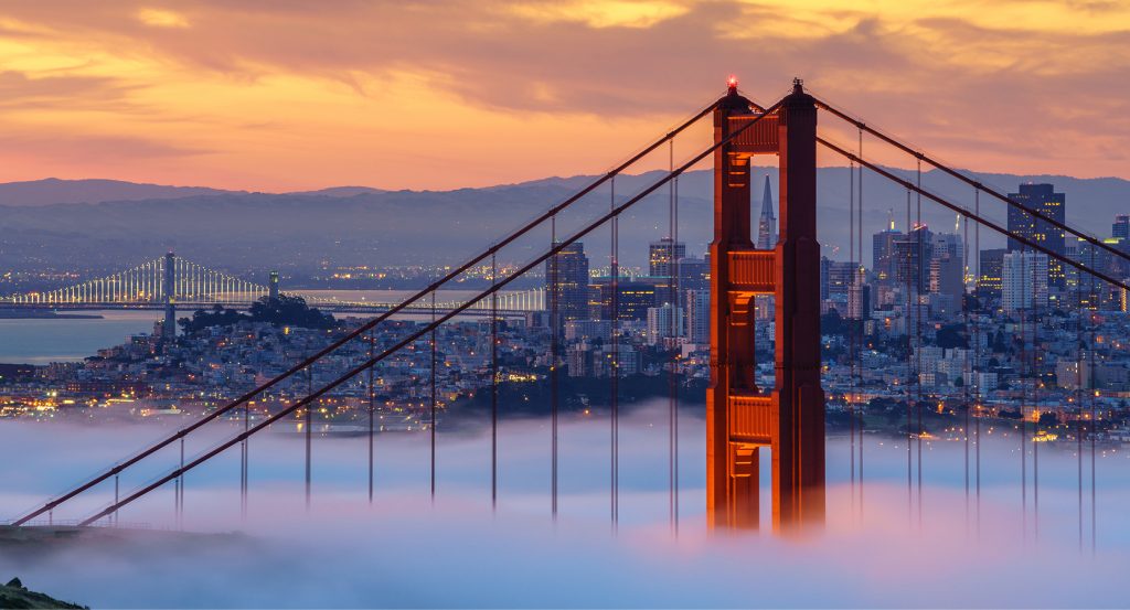 San Francisco skyline behind the fog-covered Golden Gate Bridge