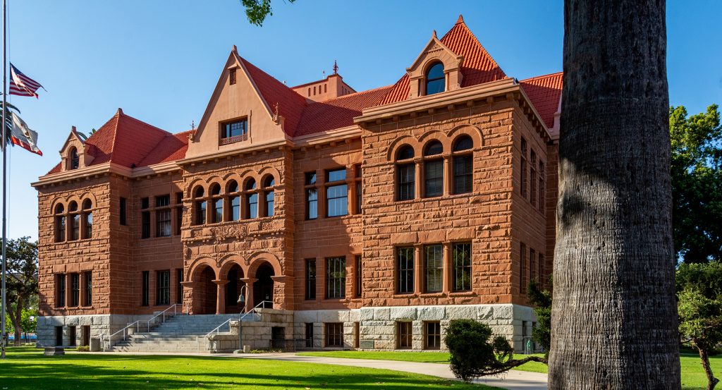 Red-roofed Romanesque revival courthouse building on a sunny day in downtown Santa Ana.