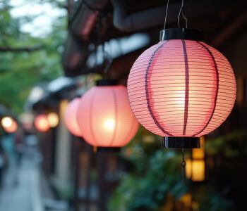 Traditional pink paper lanterns glowing along a narrow alleyway in Kyoto, Japan