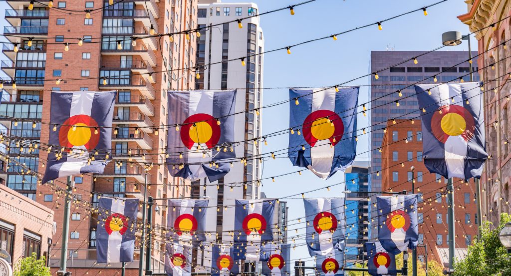 Festive string lights and flags illuminating buildings in Denver’s Larimer Square.