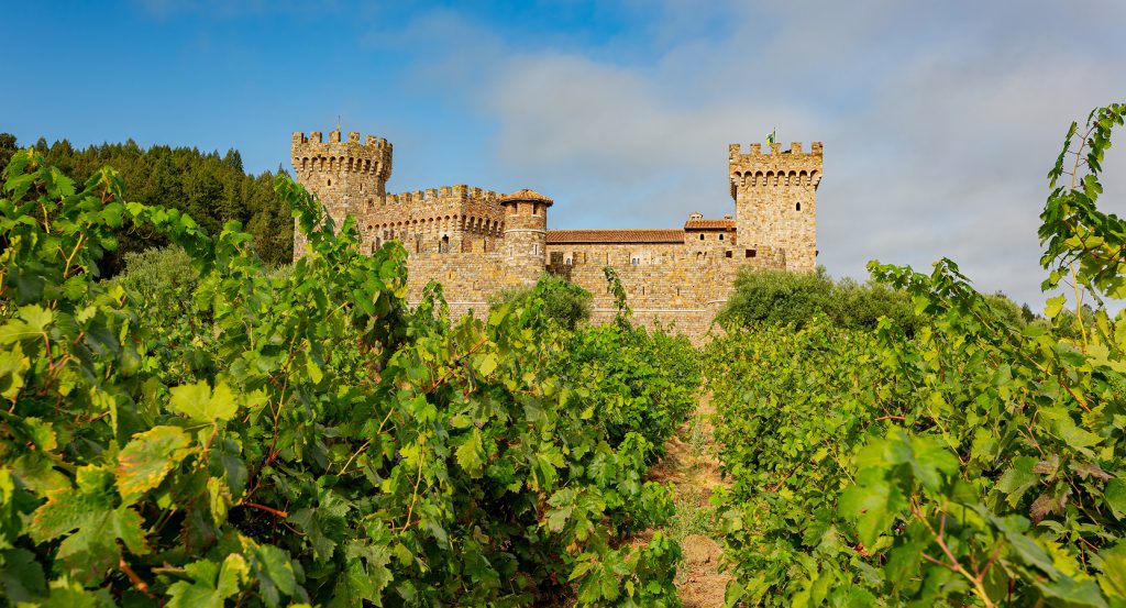 Stone castle at Castello di Amorosa, surrounded by lush vineyards in Napa Valley