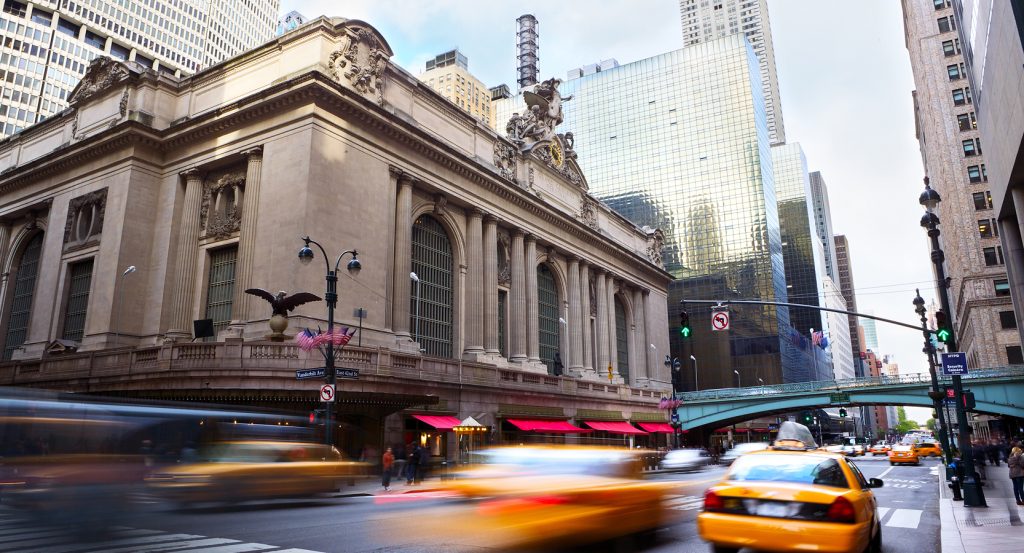 Grand Central Terminal in New York City, captured with motion blur from fast-moving traffic.
