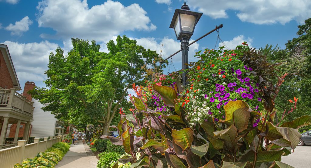 Historic lamppost with vibrant hanging flowers along a picturesque street in Niagara-on-the-Lake.