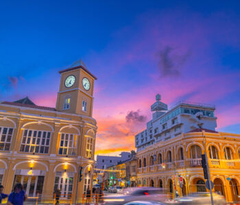 Phuket Old Town clock tower and Sino-Portuguese buildings glowing at sunset.