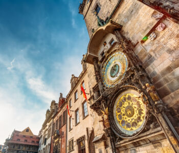 The Astronomical Clock in Prague’s Old Town glowing under the afternoon sky.
