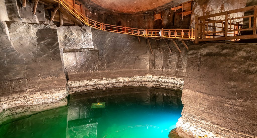 Underground emerald pool with wooden walkway in Polish salt mine
