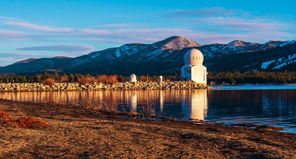 Morning light reflects off Big Bear Lake near the domed observatory and mountain backdrop.