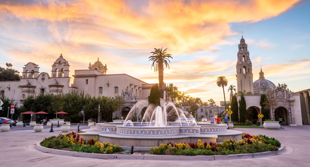 Historic buildings and palm trees glowing at sunset in San Diego’s Balboa Park