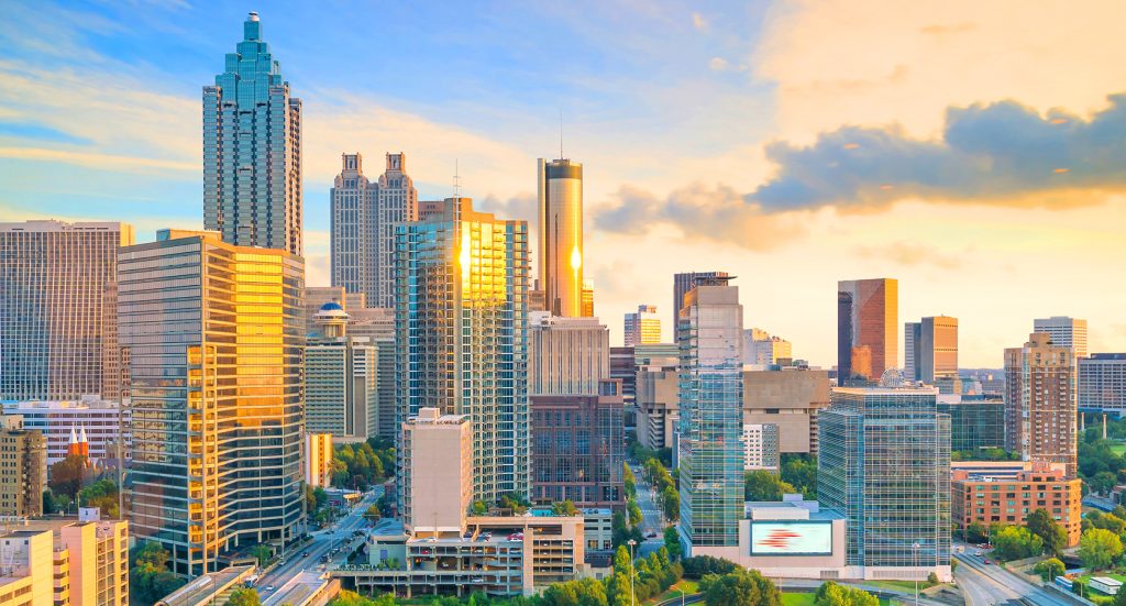 A panoramic shot of Atlanta’s high-rise skyline at golden hour, showcasing the Bank of America Plaza and Peachtree Street.