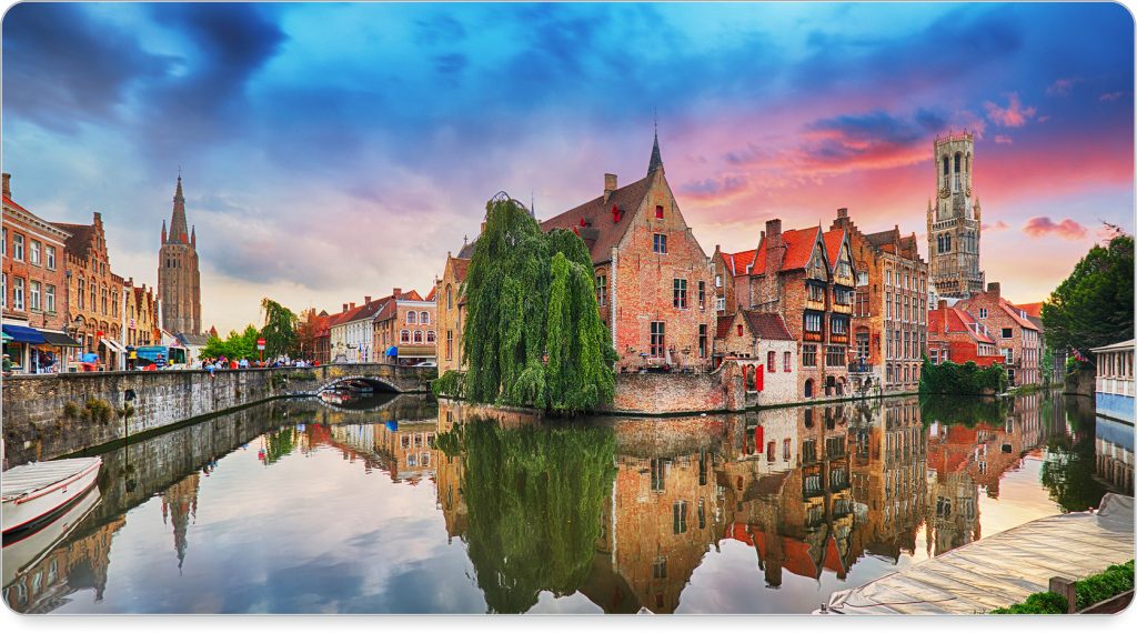 A canal boat gliding through Brugge’s waterway, framed by blooming flowers and stone bridges.