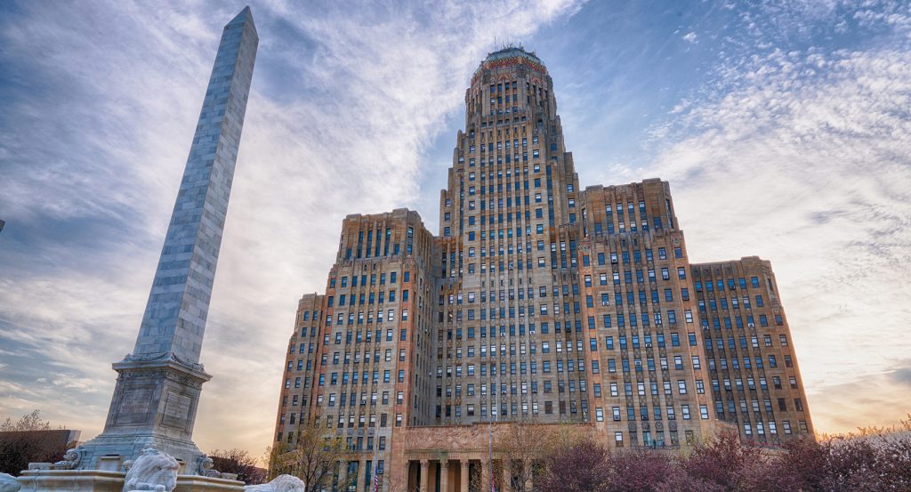 Art Deco Buffalo City Hall towers above the McKinley Monument under a dramatic evening sky