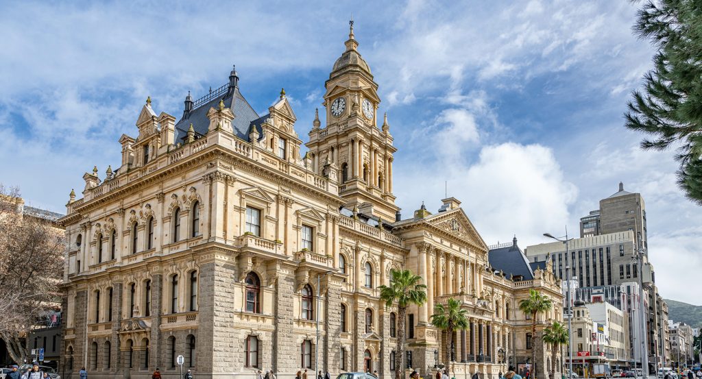 Ornate colonial-era architecture of Cape Town’s City Hall with palm trees out front