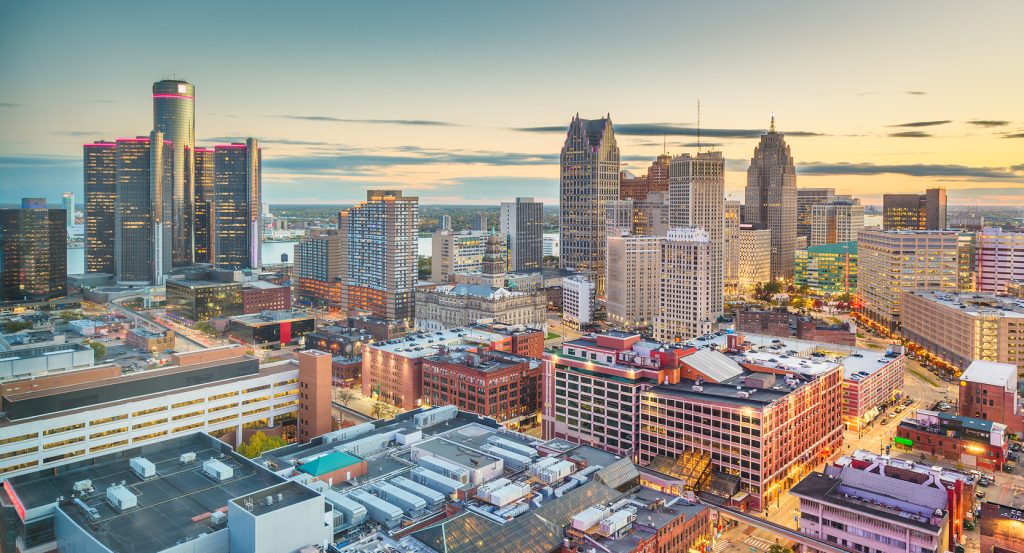 Panoramic shot of Detroit’s urban core featuring skyscrapers and warm twilight light