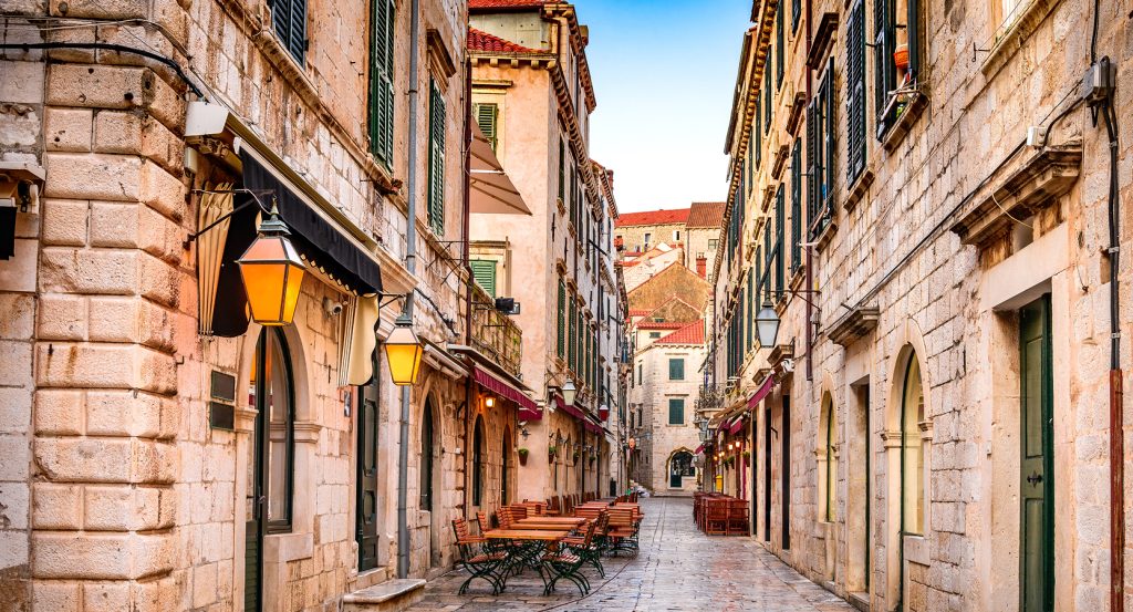 Quiet cobblestone street lined with historic buildings and lanterns in Dubrovnik