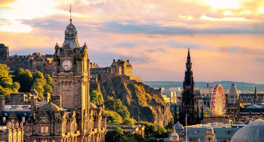 Dramatic skyline of Edinburgh with historic architecture and golden-hour glow.