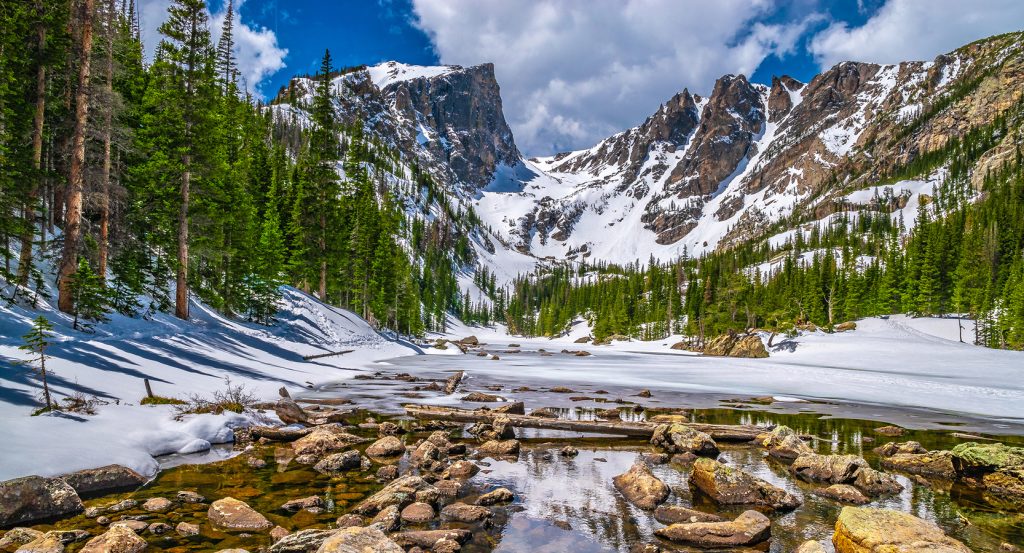 Estes Park’s frozen lake framed by snowy peaks and forest