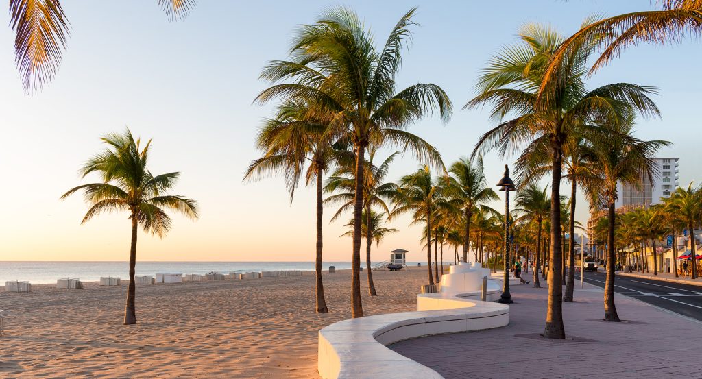 Early morning sun casting warm light over Fort Lauderdale’s beachfront promenade and iconic palms.