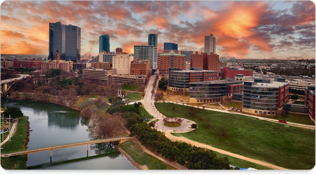Downtown Fort Worth skyline lit up at dusk, with Sundance Square bustling below.