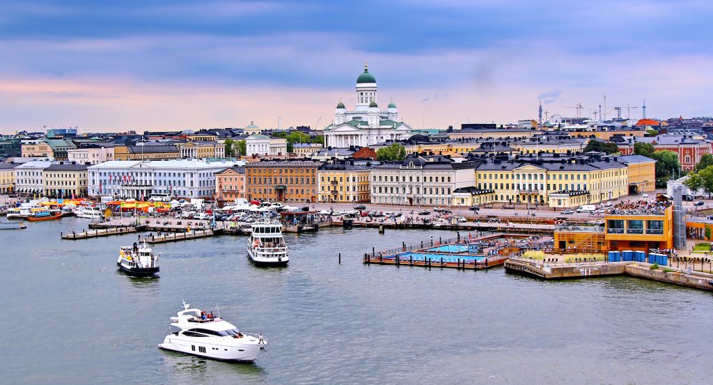 Waterfront scene of Helsinki featuring colorful buildings, yachts, and neoclassical architecture