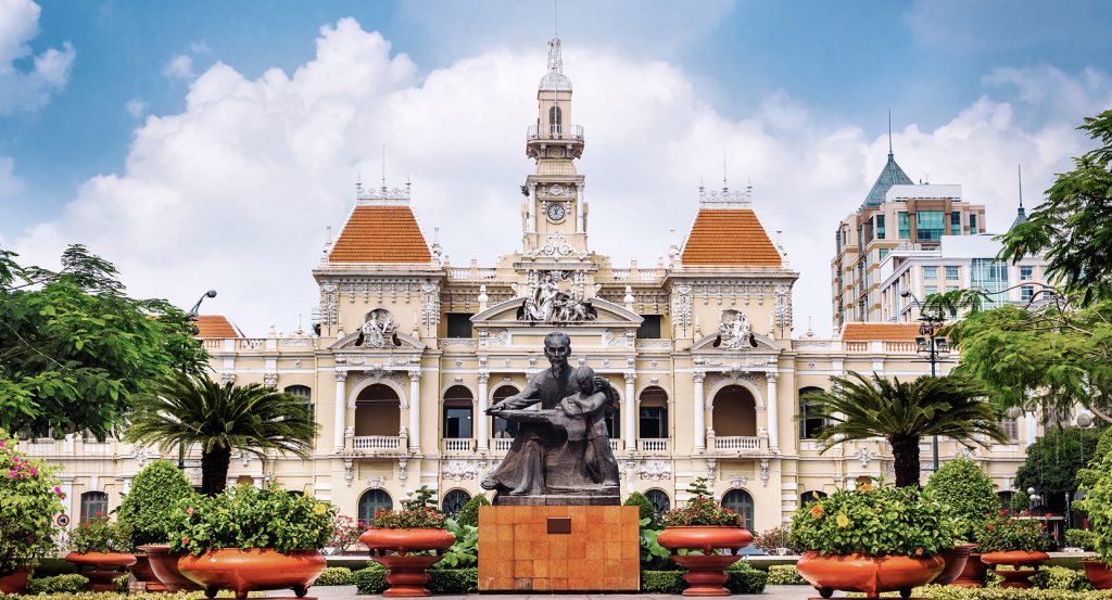 Historic French architecture meets modern skyscrapers at the iconic People’s Committee Hall in Ho Chi Minh City.