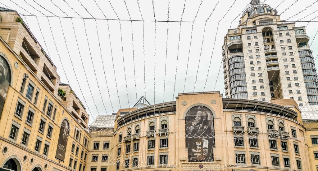 Urban cityscape of Johannesburg’s Nelson Mandela Square, framed by elegant buildings and high-rise towers.