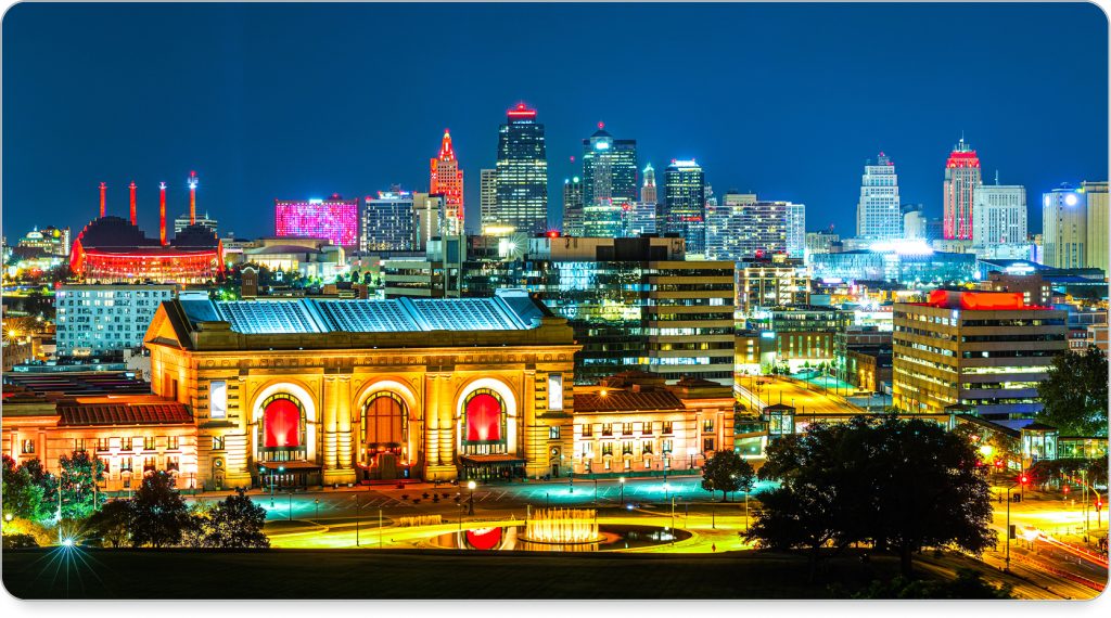 Union Station lit up at dusk, with streetcars gliding past in the foreground.