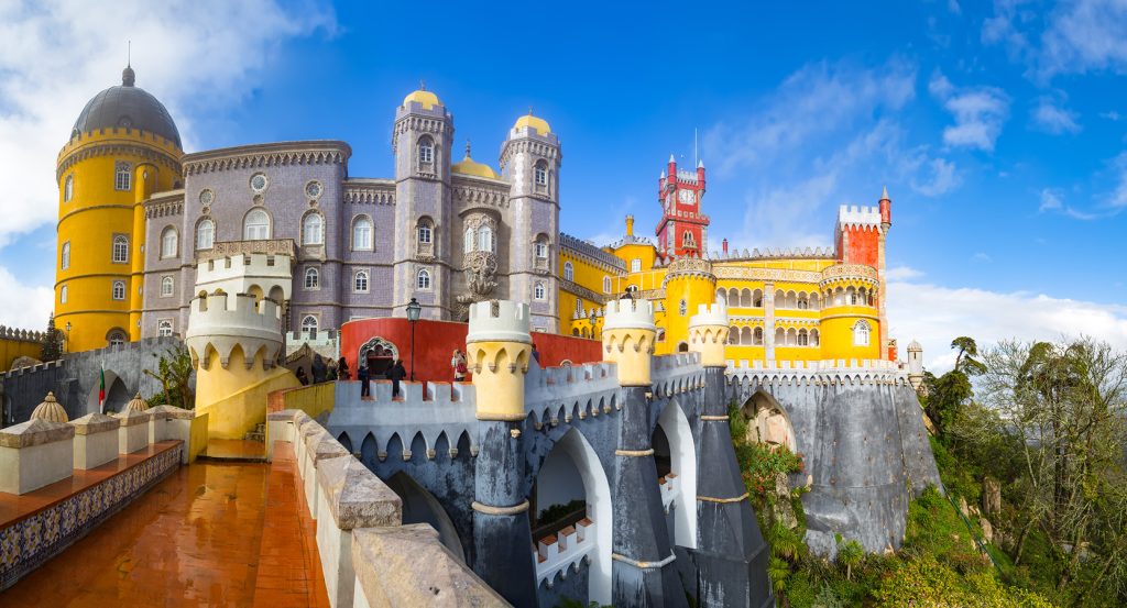 Vibrant view of Pena Palace in Sintra near Lisbon, bursting with bold reds, yellows, and whimsical fairytale architecture.