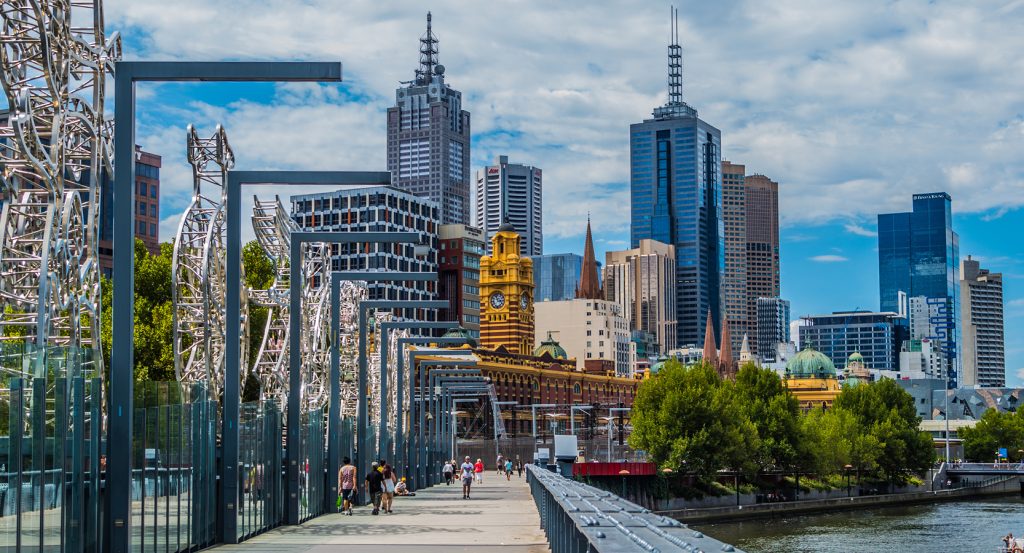 Pedestrian bridge framed by metallic sculptures in Melbourne’s city center
