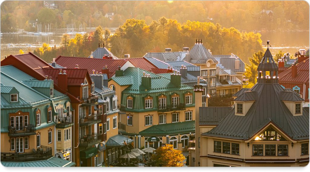 A couple riding a ski lift above Mont-Tremblant’s autumn foliage, wrapped in cozy layers.