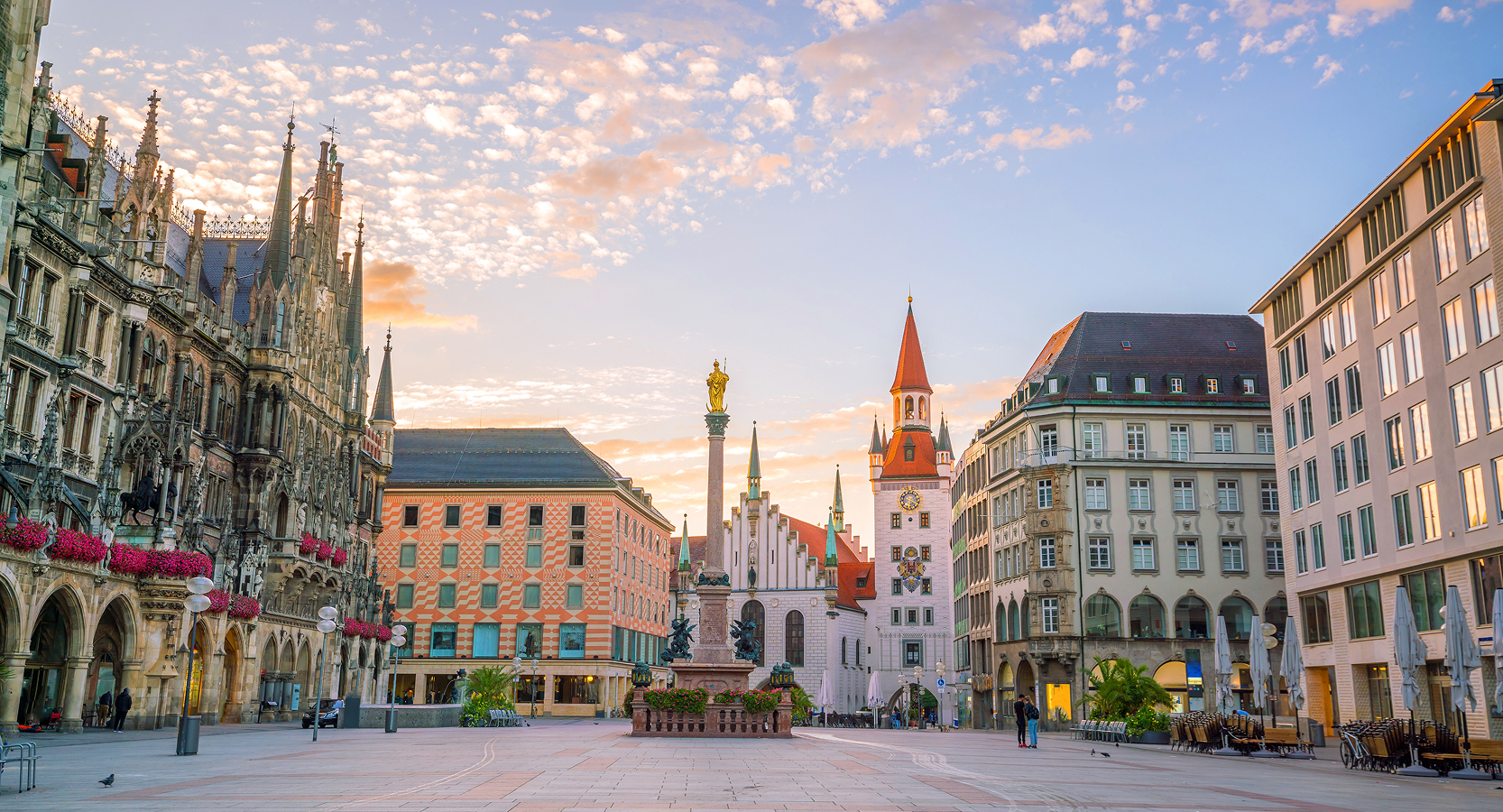 Historic city square in Munich with gothic and baroque buildings lit by early morning light and a soft sky overhead.
