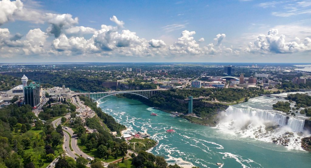 Sweeping panorama of Niagara Falls, showing both American and Canadian sides under dramatic skies.