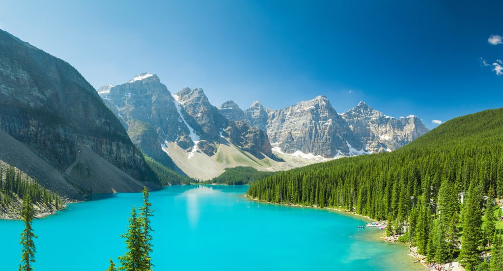 Crystal-clear Moraine Lake framed by the rugged Valley of the Ten Peaks under a bright summer sky.