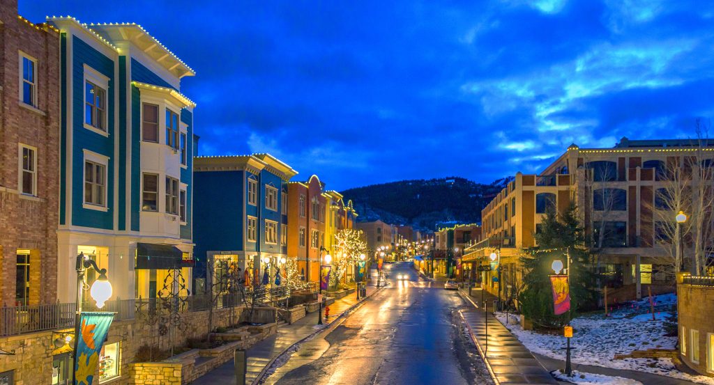 Evening sets in on Park City’s snow-dusted downtown, framed by alpine hills and cozy storefronts.