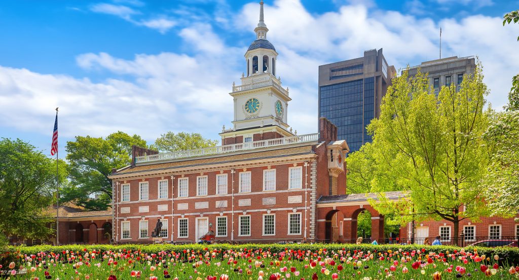 Red-brick colonial building in Philadelphia with clock tower and gardens