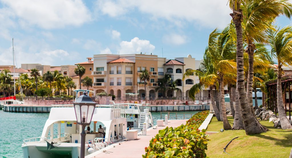 Lush waterfront promenade with yachts and resort-style villas in the Dominican Republic