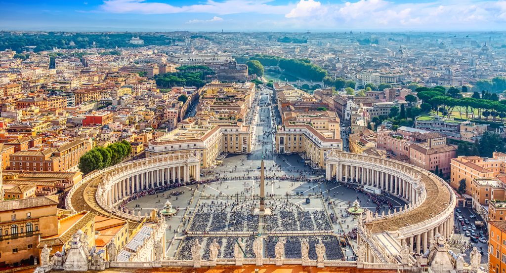 Panoramic scene of Rome with the iconic colonnade of St. Peter’s Square leading into the Eternal City.