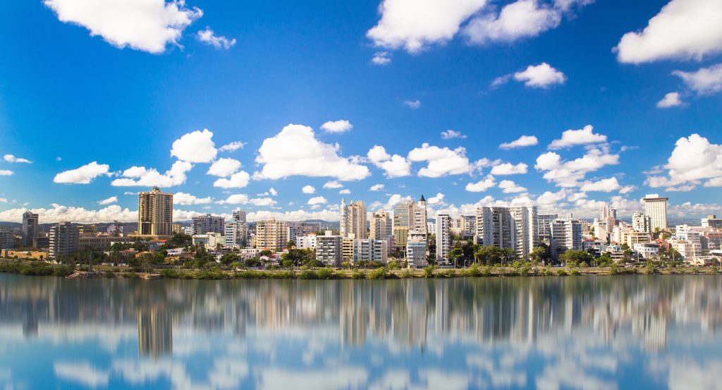 Modern cityscape of San Juan, Puerto Rico, mirrored perfectly on a still waterfront.
