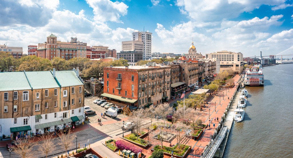River Street in Savannah with boats docked and spring trees blooming