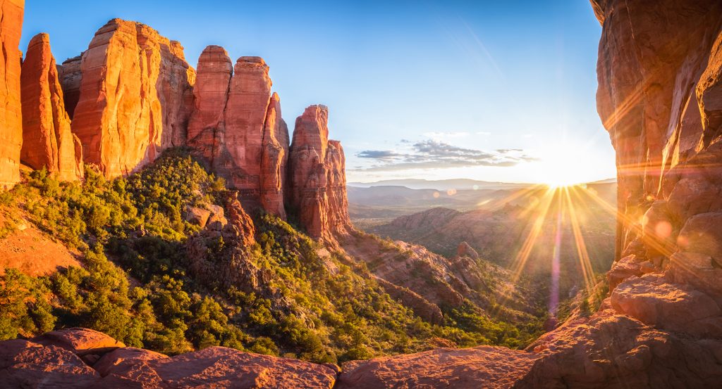 Panoramic view of Sedona’s sandstone cliffs glowing in golden morning light.