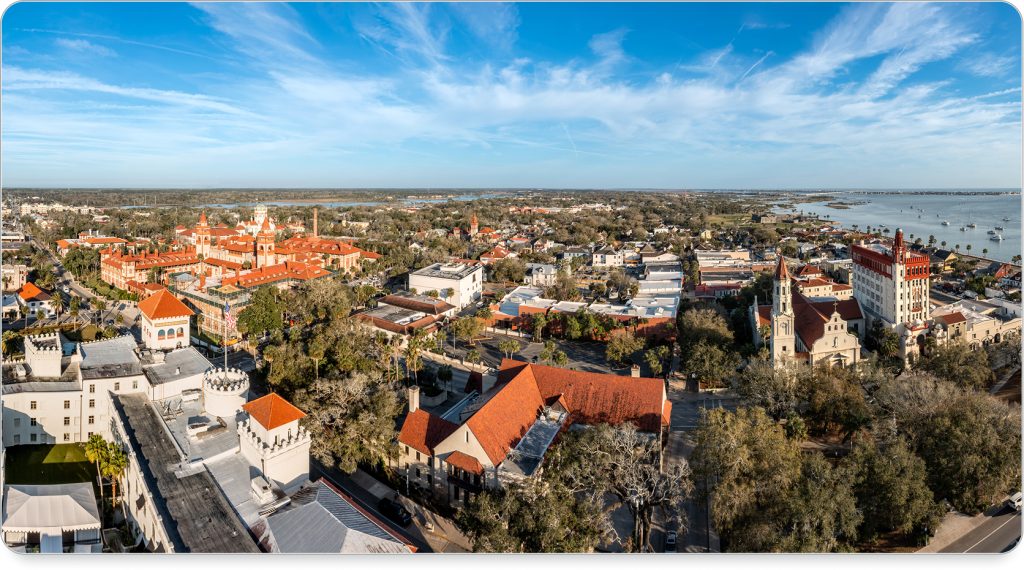 A cobblestone street in St. Augustine lined with lanterns, palm trees, and historic charm.