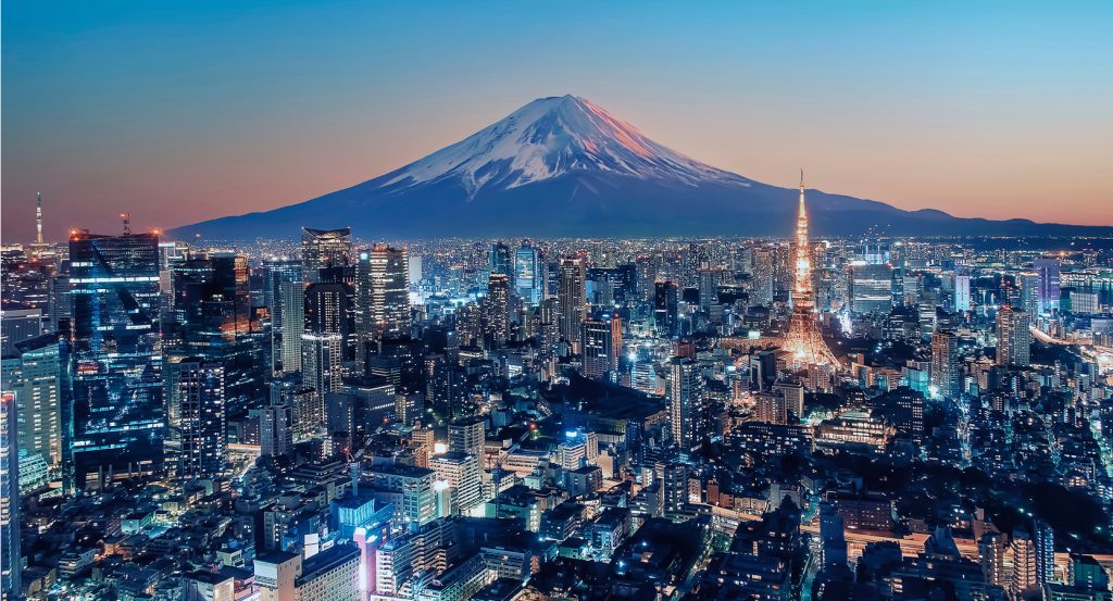 Tokyo Tower glowing at sunset against the silhouette of Mount Fuji