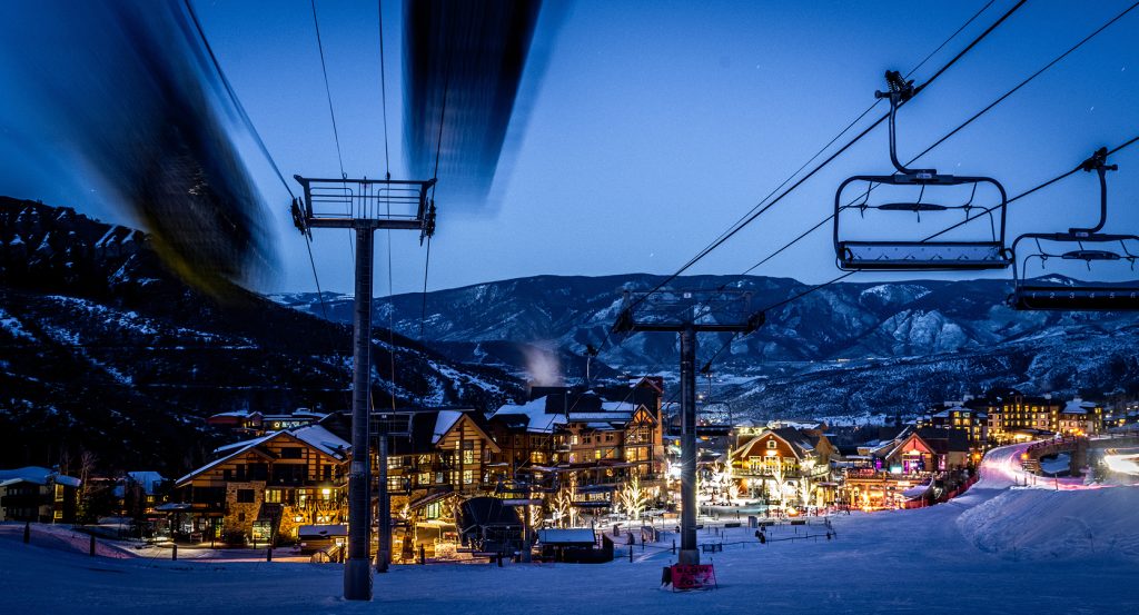 Evening descends on Vail, Colorado, as ski lifts glide above the twinkling alpine village