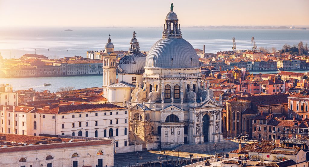Baroque domes rise above Venetian rooftops near the Grand Canal in Italy’s floating city.