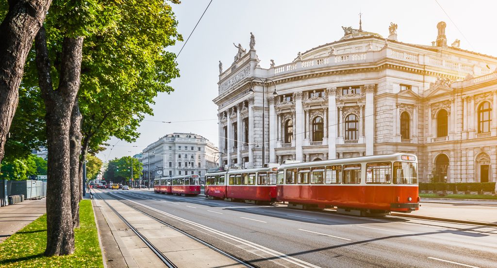 Tree-lined street with vintage tram and ornate architecture in Vienna