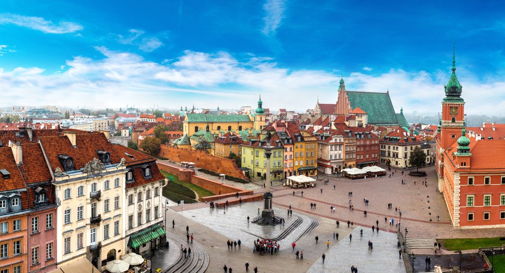 Vibrant aerial scene of Warsaw’s historic center with red rooftops and the Royal Castle in view