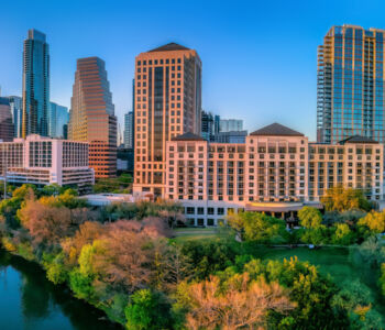 Austin skyline rising above Lady Bird Lake at golden hour in downtown Texas